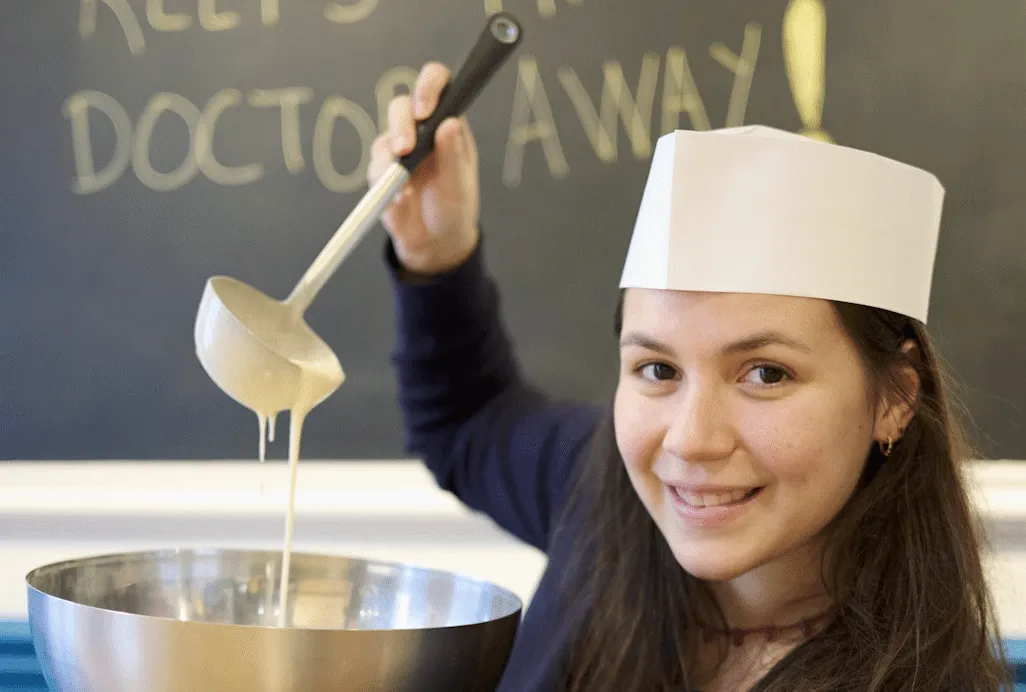 Girl pouring waffle batter during a workshop in Ghent