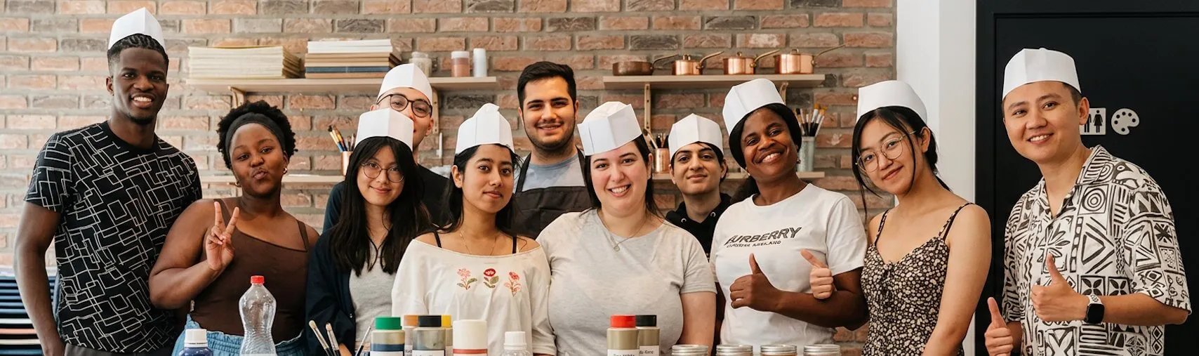 Group of happy participants wearing chef hats at our top-rated Ghent waffle workshop