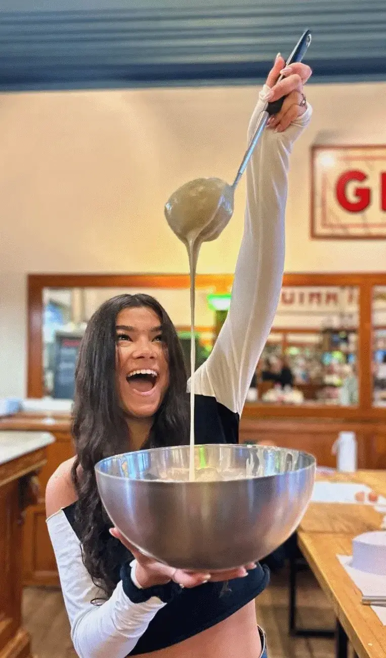 Happy participant pouring waffle batter at the Ghent workshop